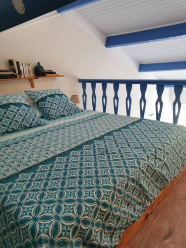 - un lit avec une couette verte dans une chambre dans l'établissement U Mirante, Panoramic terrace over gulf sunset, à Patrimonio