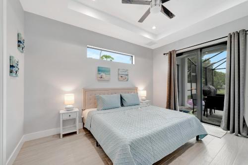 a white bedroom with a bed and a window at Seashell of the Ball in Cape Coral
