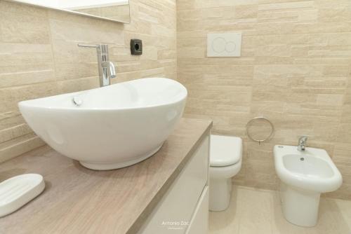 a bathroom with a white sink and a toilet at Il vecchio arco in Novoli