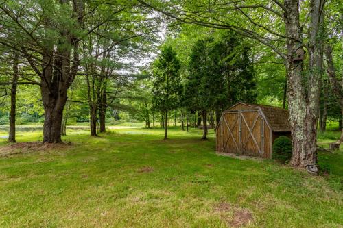 an outbuilding in the middle of a field with trees at Bluebird Manor on the Water, 2 Acres & Amenities in Liberty