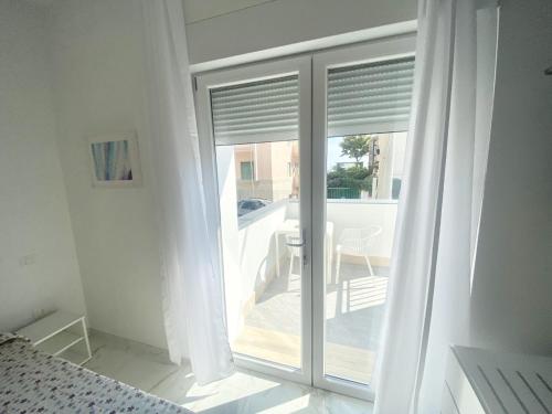 a bedroom with a sliding glass door to a patio at IL VIAGGIATORE RELAIS SUL MARE in Gaeta