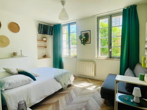 a bedroom with a bed and two windows at Le Tropical - Studio avec terrasse in Angoulême