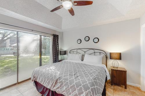 een slaapkamer met een bed, een plafondventilator en een raam bij Camp Warnecke Estates Unit B104 in New Braunfels