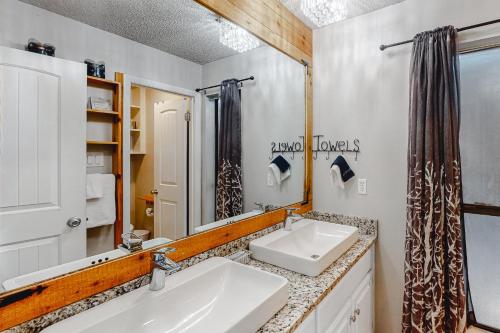 Baño con 2 lavabos y espejo en Camp Warnecke Estates Unit B104, en New Braunfels