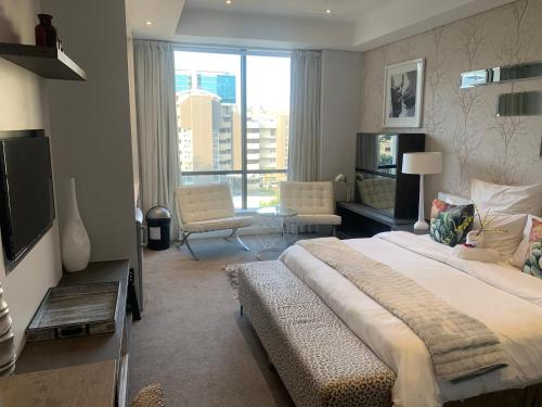 um quarto com uma cama grande e uma janela grande em Sandton Skye Stylish Apartment free WIFI & Gym em Joanesburgo