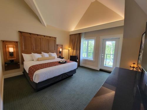 duży pokój hotelowy z dużym łóżkiem i oknami w obiekcie Kilmorey Lodge w mieście Waterton Park