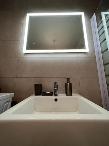 a bathroom with a sink with a light above it at Brand new apartment 2 mins from Seafront in St Paul's Bay