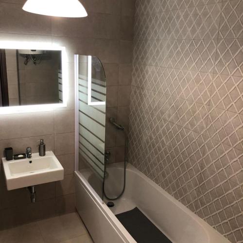 a bathroom with a sink and a shower and a mirror at Brand new apartment 2 mins from Seafront in St Paul's Bay