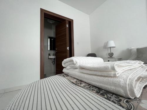 a white bedroom with a bed with white blankets at Brand new apartment 2 mins from Seafront in St Paul's Bay