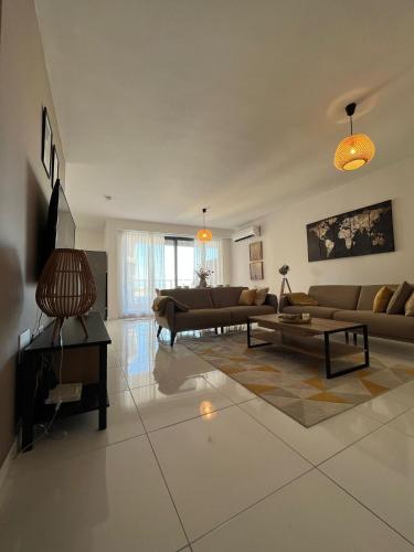 a living room with two couches and a table at Brand new apartment 2 mins from Seafront in St Paul's Bay