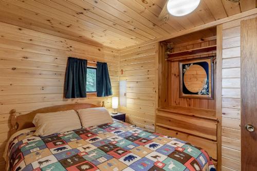 - une chambre avec un lit dans une cabane en rondins dans l'établissement Lakefront Cottage #1, à Greenville