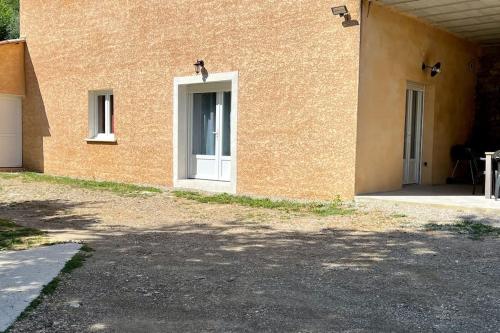 ein Gebäude mit einer weißen Tür an der Seite in der Unterkunft Charmant Logement avec piscine. in Valleraugue