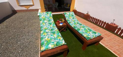 two wooden benches in a room with flowers on them at Bungalow Flor de Lirio in Mazarrón