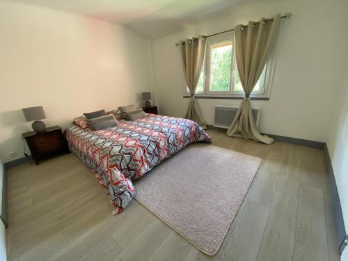 a bedroom with a bed and a window and a rug at La ferme Sainte-Damaris de la Maurienne 