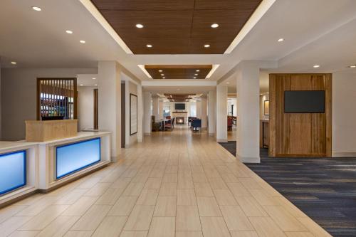 a hallway of a office building with two monitors on the wall at Holiday Inn Express & Suites Denver Airport by IHG in Denver