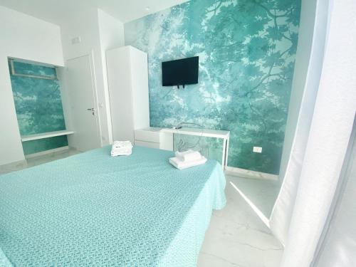 a bedroom with a bed with a tv on the wall at IL VIAGGIATORE RELAIS SUL MARE in Gaeta