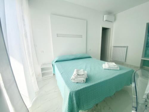 a bedroom with a bed with towels on it at IL VIAGGIATORE RELAIS SUL MARE in Gaeta