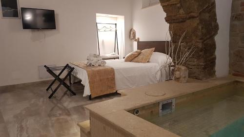 a bedroom with a bed and a tv on the wall at Janara - Arco di Traiano in Benevento