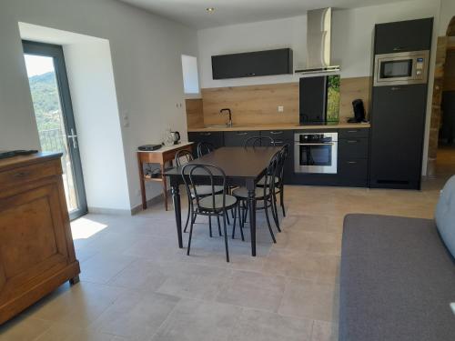 une cuisine et une salle à manger avec une table et des chaises dans l'établissement Jolie maison avec vue, dans bâtisse cévenole, à Lentillères