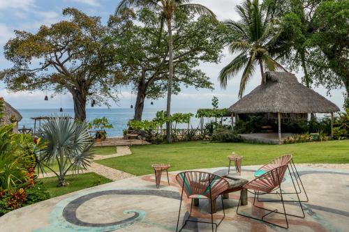 un resort con sedie, tavolo e gazebo di Amaca Beach Hotel - Eco Resort Quiimixto a Quimixto