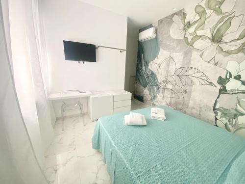 a bedroom with a green bed and a wall with flowers at IL VIAGGIATORE RELAIS SUL MARE in Gaeta