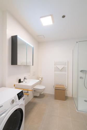 a white bathroom with a washing machine in it at Vienna Residence, Marina Tower - Danube in Vienna