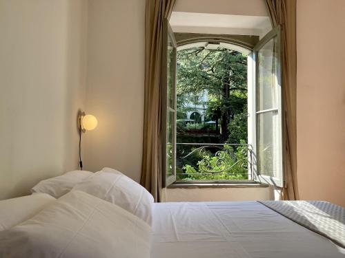 um quarto com uma cama e uma janela aberta em [AvocadoHouse] Incredibile Appartamento Con Vista em San Pellegrino Terme