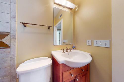 a bathroom with a sink and a toilet and a mirror at Yellow Brick Road House in Oak Bluffs