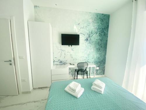 a bedroom with a bed with two towels on it at IL VIAGGIATORE RELAIS SUL MARE in Gaeta