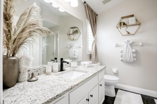 uma casa de banho branca com um lavatório e um WC em Remington View Retreat em Kissimmee