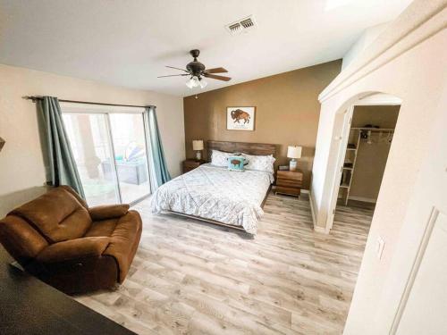 a bedroom with a bed and a chair and a ceiling fan at PRIVATE VIEW ON THE LAKE SIDE OF 95! Sleeps 16 in Lake Havasu City
