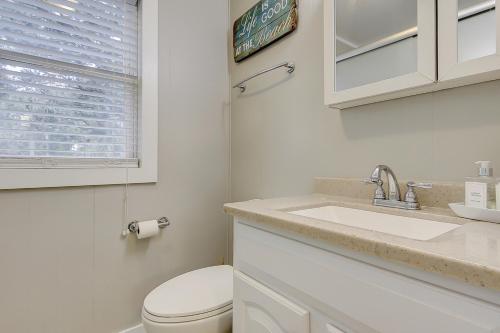 a white bathroom with a toilet and a sink at SeaEscape in Folly Beach