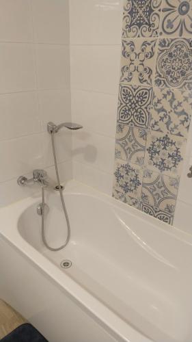 d'une baignoire avec un robinet et un rideau de douche. dans l'établissement Mieszkanie, à Kołobrzeg