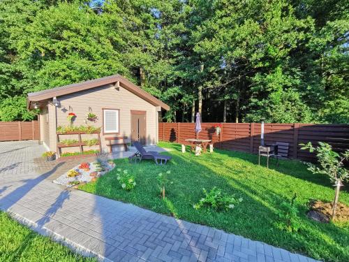 a backyard with a small shed and a fence at Poilsio namelis Nemirseta in Palanga