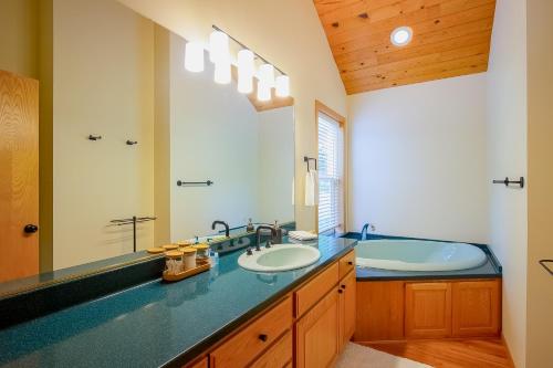 a bathroom with two sinks and a large mirror at Siuslaw River House in Mapleton