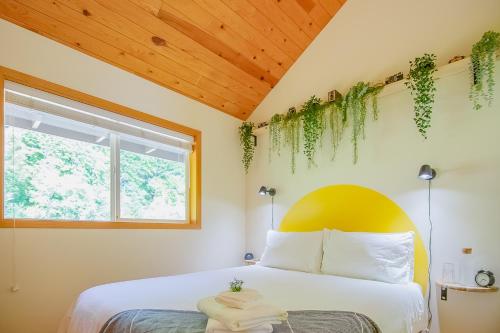 a bedroom with a bed with plants on the wall at Siuslaw River House in Mapleton