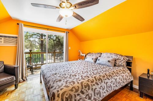 um quarto com paredes amarelas e uma cama com uma ventoinha de tecto em Oak Ridge Landing em Groveland