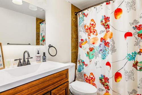 uma casa de banho com uma cortina de chuveiro, um WC e um lavatório. em Oak Ridge Landing em Groveland
