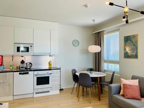 Il comprend une cuisine et un salon avec une table et des chaises. dans l'établissement Bellarova Apartments II, à Rovaniemi