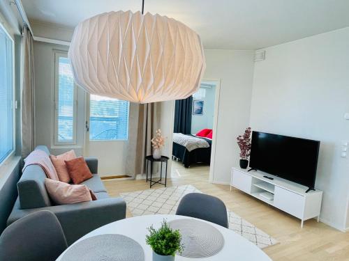 - un salon avec un canapé et un grand lustre dans l'établissement Bellarova Apartments II, à Rovaniemi
