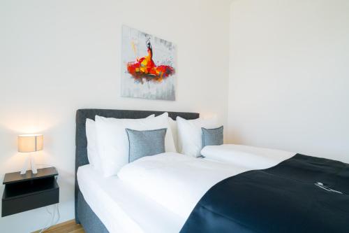 a bedroom with a large white bed and a lamp at Vienna Residence, Marina Tower - Danube in Vienna