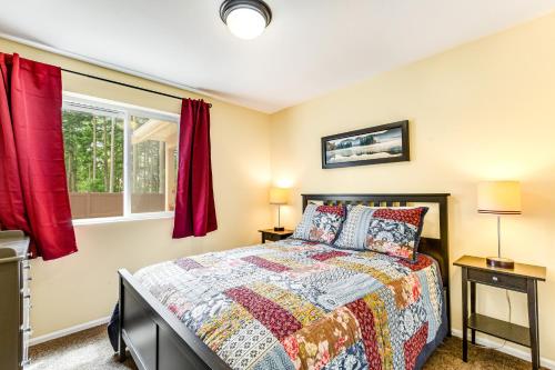 a bedroom with a bed and a window with red curtains at Port Townsend Kala Point in Port Townsend