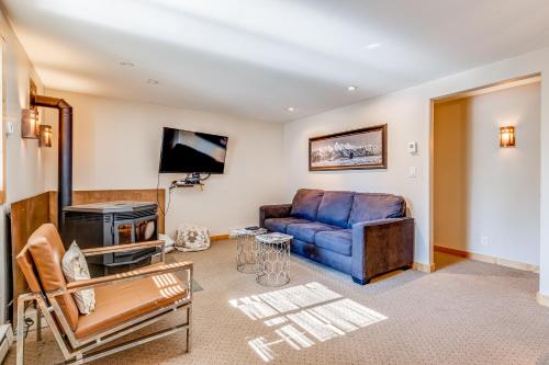 a living room with a blue couch and a tv at Tensleep B9 in Teton Village
