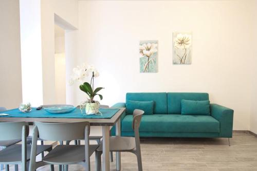 a living room with a blue couch and a table at Appartamenti Nicolò in Baunei