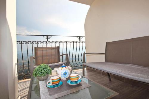 a balcony with a bench and a table and a chair at Appartamenti Nicolò in Baunei