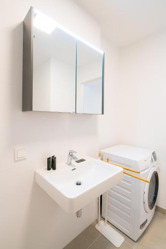 a bathroom with a sink and a washing machine at Vienna Residence, Marina Tower - Danube in Vienna