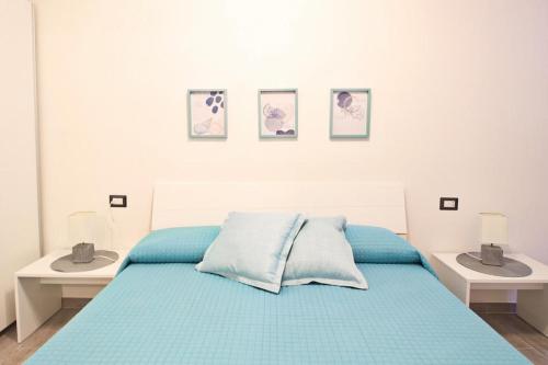 a bedroom with a bed with blue sheets and two sinks at Appartamenti Nicolò in Baunei