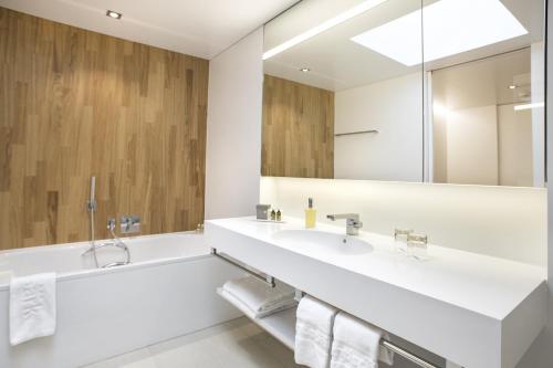 ein Badezimmer mit zwei Waschbecken und einem großen Spiegel in der Unterkunft Hotel Säntispark in St. Gallen