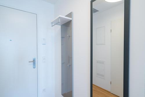 a mirror in a room with white closets at Vienna Residence, Marina Tower - Danube in Vienna