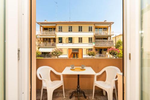 a table and chairs on a balcony with a building at Monti Guesthouse in Mestre